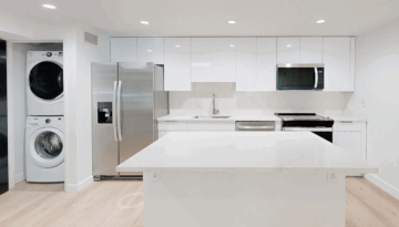 Modern kitchen with white cabinets and appliances.