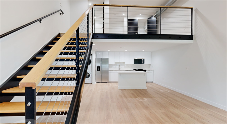 Modern loft with staircase and open kitchen.