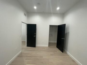 Empty room with hardwood floor and open doors