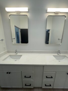 Modern double sink bathroom vanity with mirrors.