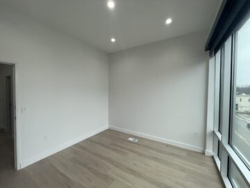 Empty room with wooden floor and large windows