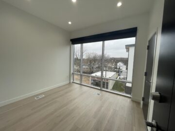 Empty room with large windows and wooden floor