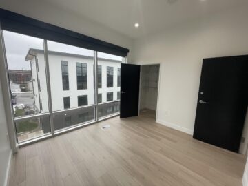 Empty room with large windows and closet.