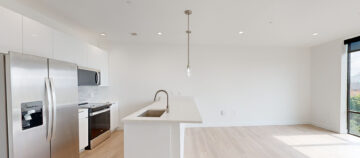 Modern kitchen with island, stainless appliances.