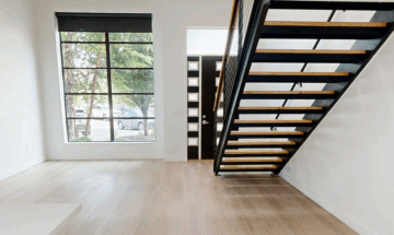 Modern interior with staircase and large window view.