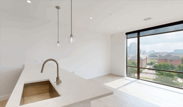 Modern kitchen with city view through large windows.