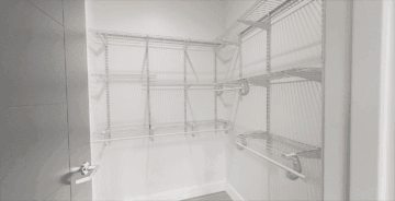 Spacious walk-in closet with white wire shelving and organization racks.