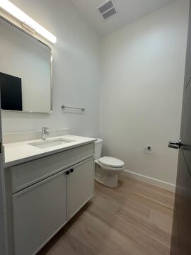 Minimalist bathroom with modern fixtures and wooden flooring.