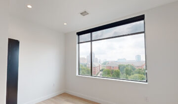 Modern empty room with large window and city skyline view