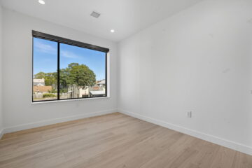 Bright empty room with large window and natural light in the 616, modern design for urban living.