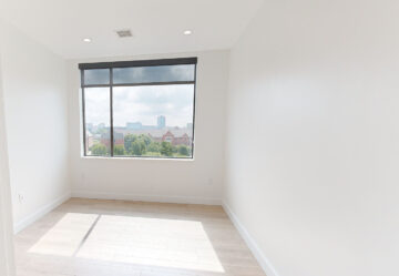 Empty modern room with large window and city skyline view