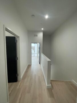 Modern hallway with wooden floor and open door