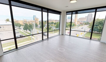 Empty modern apartment room with floor-to-ceiling city views
