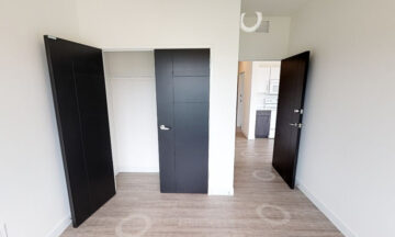 Modern bedroom with black doors and open closet