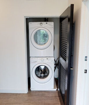 Stacked white washer and dryer in closet