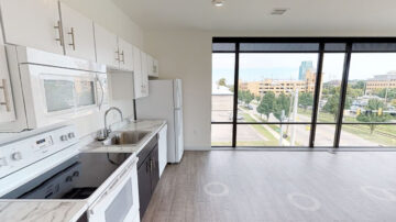 Modern apartment kitchen with floor-to-ceiling windows and city view