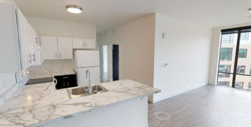 Modern apartment kitchen with marble countertop and city view