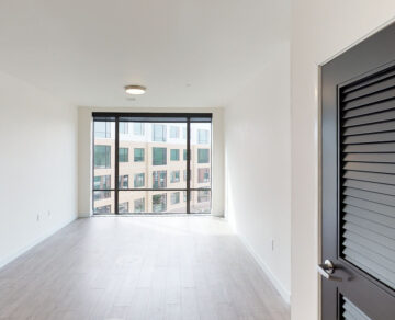 Empty modern apartment room with floor-to-ceiling windows
