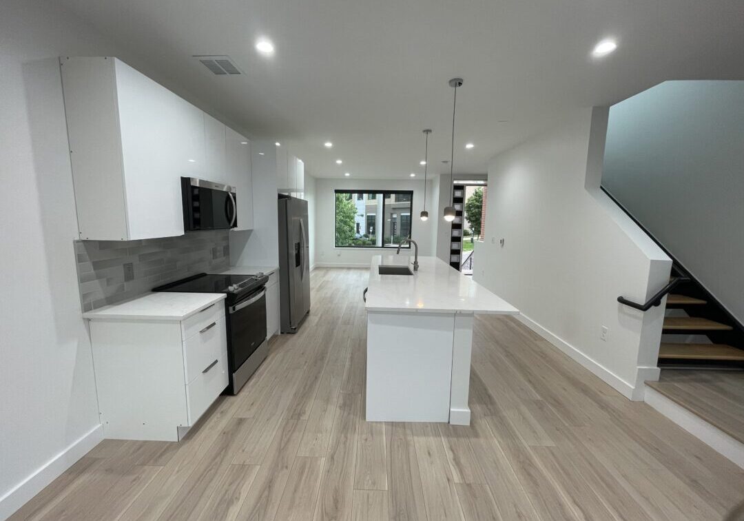 Modern minimalist kitchen interior with white cabinets and stainless steel appliances at The 616.