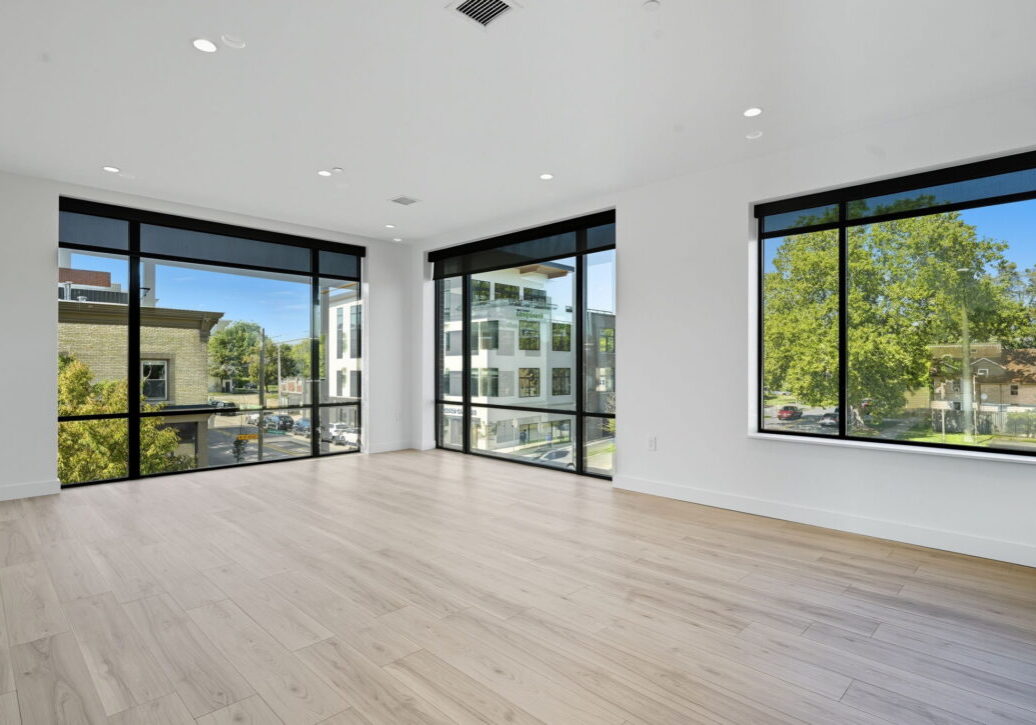 Bright modern apartment interior with large floor-to-ceiling windows and natural light.