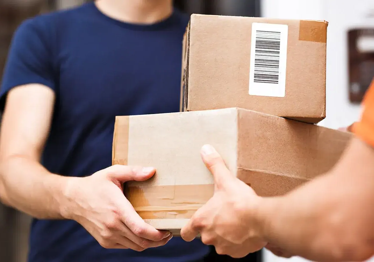Stack of packages being handed over during delivery, representing efficient logistics at The 616.