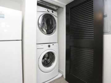 Stacked white washer and dryer in compact laundry closet