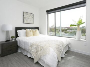 Modern bedroom with city view and white bedding